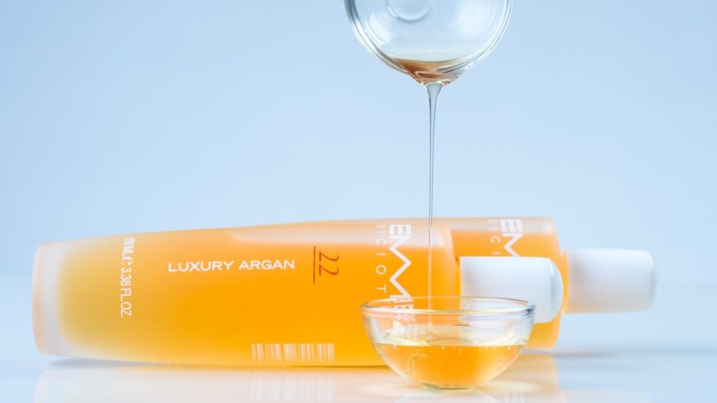 Argan çekirdeklerinin yanında duran cam şişede argan yağı