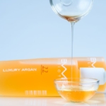 Argan çekirdeklerinin yanında duran cam şişede argan yağı