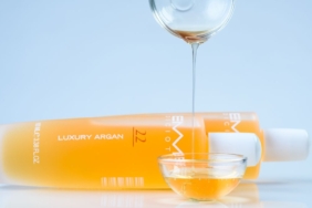 Argan çekirdeklerinin yanında duran cam şişede argan yağı