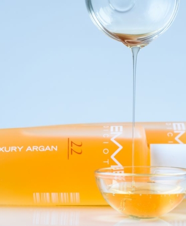 Argan çekirdeklerinin yanında duran cam şişede argan yağı