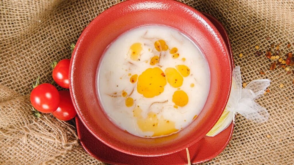 Kasede limon dilimi ve pul biberli tereyağı ile servis edilen mercimek çorbası