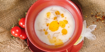 Kasede limon dilimi ve pul biberli tereyağı ile servis edilen mercimek çorbası