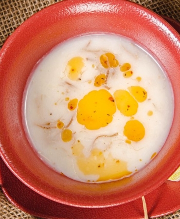 Kasede limon dilimi ve pul biberli tereyağı ile servis edilen mercimek çorbası