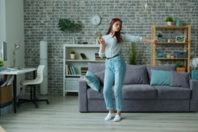 Evinin salonunda neşeyle dans eden kadın