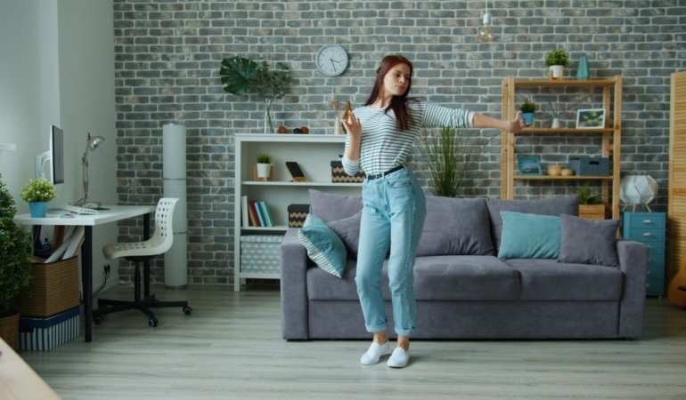 Evinin salonunda neşeyle dans eden kadın