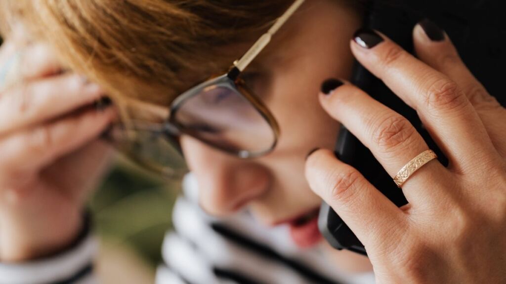 Telefonuna kaygıyla bakan genç kadın