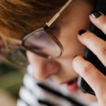 Telefonuna kaygıyla bakan genç kadın