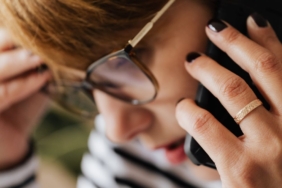 Telefonuna kaygıyla bakan genç kadın