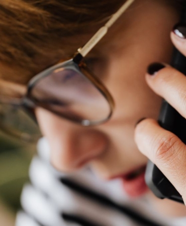 Telefonuna kaygıyla bakan genç kadın