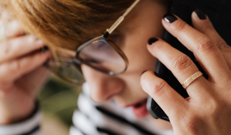Telefonuna kaygıyla bakan genç kadın