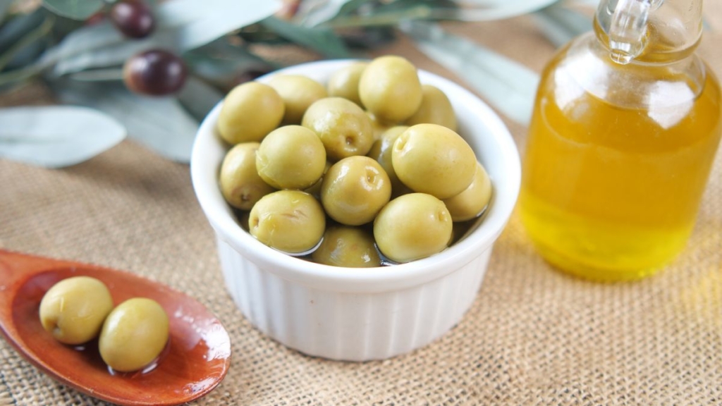 Cam şişede organik zeytinyağı ve taze zeytin dalları