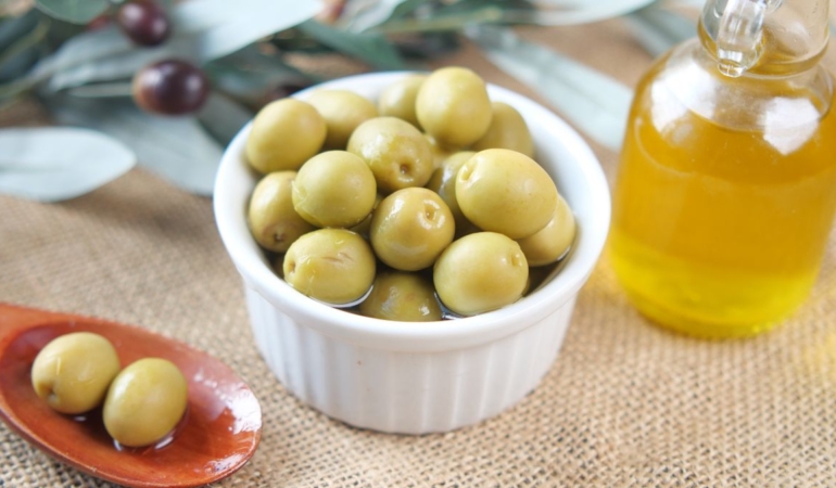 Cam şişede organik zeytinyağı ve taze zeytin dalları