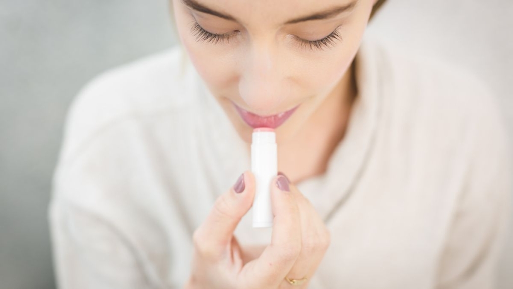 Dudaklarına koruyucu balm süren kadın