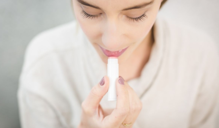 Dudaklarına koruyucu balm süren kadın